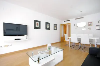 a living room with a tv and a table and chairs at Apartamentos Port in Valencia