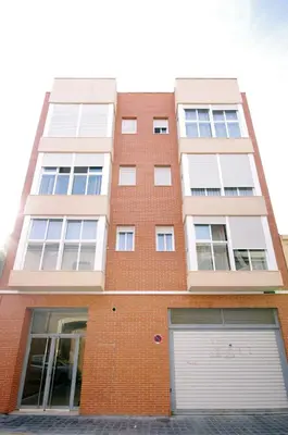a red brick building with a white garage at Apartamentos Port in Valencia