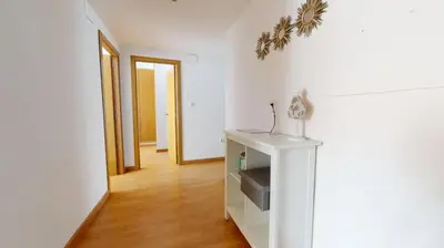 a room with white walls and wooden floors and a hallway at Apartamentos Port in Valencia