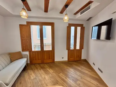 a living room with a couch and two windows at Casa del Carmen in Valencia