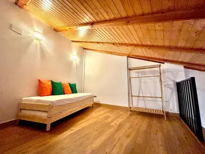 a room with a bed with orange and green pillows at Casa del Carmen in Valencia
