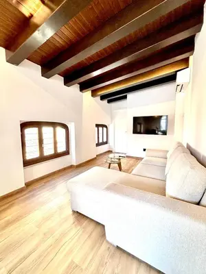 a bedroom with a white bed with a window at Casa Valencians in Valencia