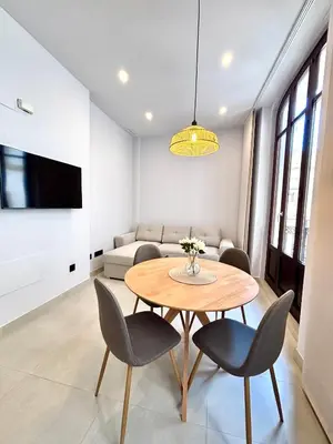 a kitchen and living room with a microwave and a table at Casa Valencians in Valencia