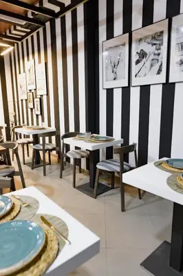 a dining room with tables and chairs and striped walls at The Little Corner B&B in Valencia