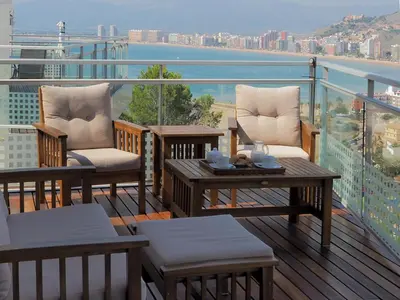 a balcony with chairs and tables and a view of the water at Villa with magnificants sea views on Cullera bay. in Faro de Cullera