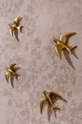 four gold birds on a wall with a wallpaper at Viva Valencia Apartments in Valencia