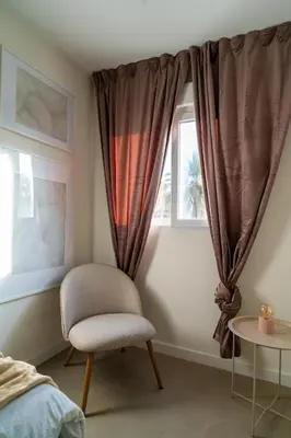 a bedroom with a chair and a window at Viva Valencia Apartments in Valencia