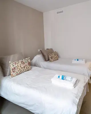 two beds in a room with a white couch at Viva Valencia Apartments in Valencia