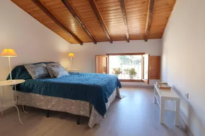 a bedroom with a bed with a blue bedspread and a window at JERICA ALOHA in Jérica