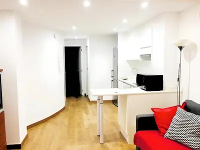 a living room with a desk and a red couch at Estudio en el Corazón de Valencia al lado Catedral in Valencia