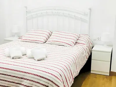 a white bed with two pillows on top of it at Estudio en el Corazón de Valencia al lado Catedral in Valencia