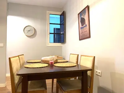 a dining room table with chairs and a clock on the wall at 2 Apartamento TERRAZA Free Wifi in Valencia