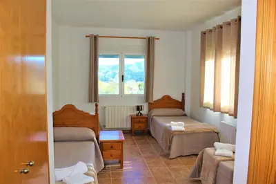 a bedroom with two beds and a window at Hostal Rural Fidel Garcia Guzman in Chera