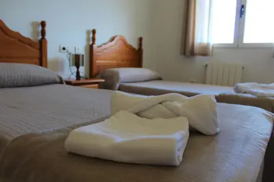 a room with two beds with white towels on a bed at Hostal Rural Fidel Garcia Guzman in Chera