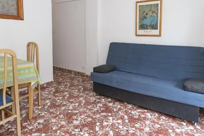 a living room with a blue couch and a table at Mar y Montana 6to 97 in Cullera