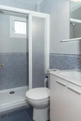 a white bathroom with a toilet and a shower at Mar y Montana 6to 97 in Cullera