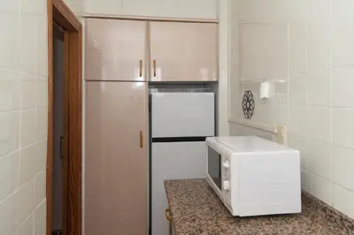 a microwave sitting on a counter next to a refrigerator at Mar y Montana 6to 97 in Cullera