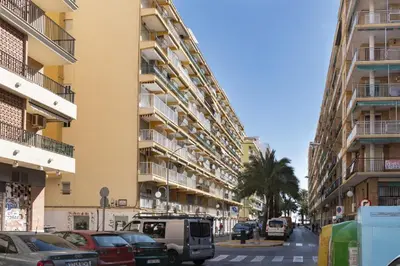 a street with cars parked in front of tall buildings at Mar y Montana 6to 97 in Cullera