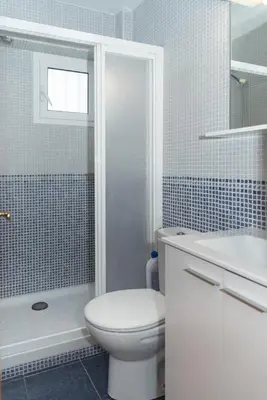 a white bathroom with a toilet and a shower at Mar y Montana 6to 97 in Cullera