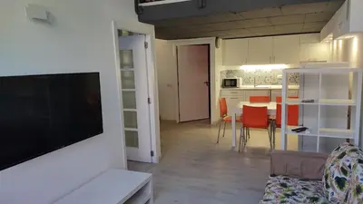 a living room with a television and a table with chairs at valencialoft in Valencia