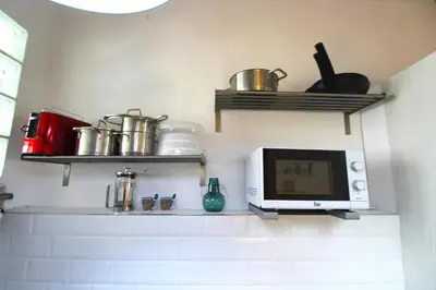 a kitchen with a microwave and shelves on the wall at Piso en el Carmen cerca del Mercado Central in Valencia