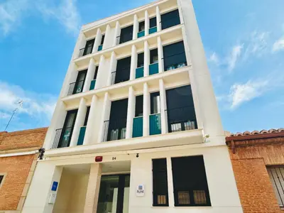 a white building with windows on the side of it at STUDIO Palomar - PalomarGroup in Alfara del Patriarca