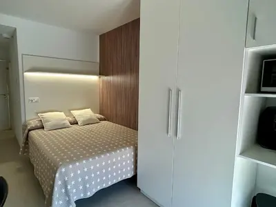a small bedroom with a bed and a cabinet at STUDIO Palomar - PalomarGroup in Alfara del Patriarca