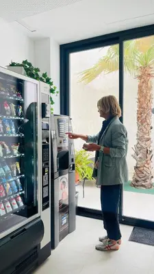 a woman standing in front of a vending machine at STUDIO Palomar - PalomarGroup in Alfara del Patriarca