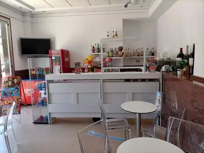 a kitchen with a counter and some chairs and a tv at Hotel Vent de Mar in Puerto de Sagunto