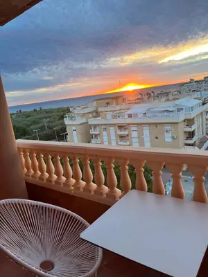 a balcony with a table and a view of a city at Hotel Vent de Mar in Puerto de Sagunto