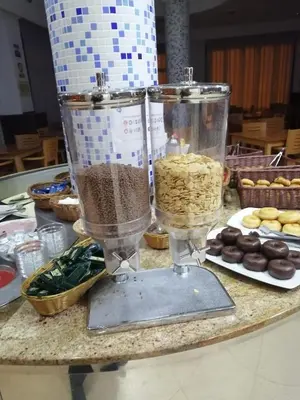 a table with a blender and a plate of donuts at Hotel Vent de Mar in Puerto de Sagunto
