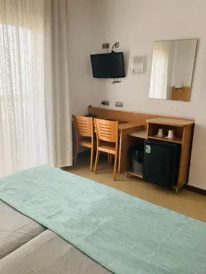 a hotel room with a desk and a television at Hotel Vent de Mar in Puerto de Sagunto