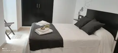 a bedroom with a large bed with a black headboard at El Enclave in Chulilla