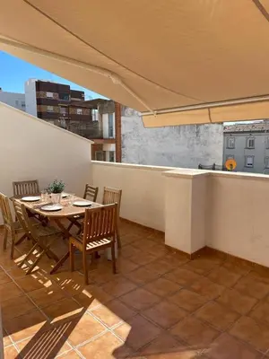 a table and chairs on a balcony with an umbrella at UIM Mediterraneo ATICO Poeta 8 Wifi in Puerto de Sagunto