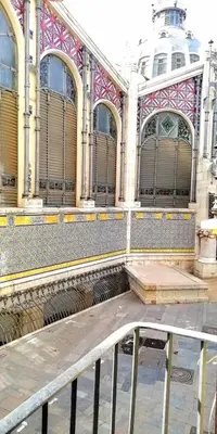 a large building with windows and a fence in front of it at Precioso Apartamento frente del Mercado Central in Valencia