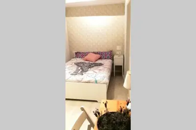 a small bedroom with a bed with a pink pillow at Precioso Apartamento frente del Mercado Central in Valencia
