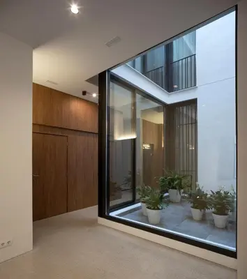 a hallway with a large window with potted plants at Dau Studios in Valencia
