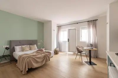 a bedroom with a bed and a table and a chair at Líbere Valencia Abastos in Valencia