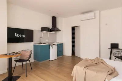a kitchen with a table and chairs in a room at Líbere Valencia Abastos in Valencia