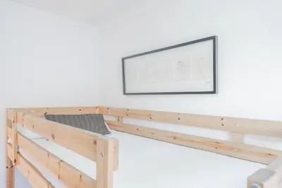 a wooden bed frame with a tv on a wall at Maritim Horizon House Port of Valencia in Valencia
