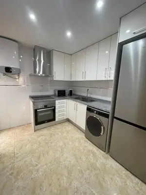 a kitchen with white cabinets and a washer and dryer at UIM Mediterraneo Poeta 1 Wifi in Puerto de Sagunto