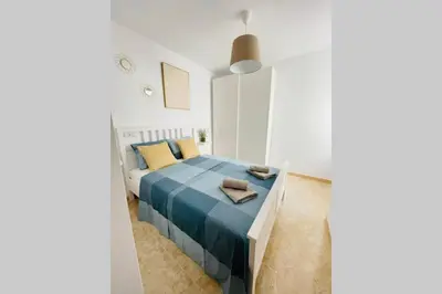 a white bedroom with a blue bed in a room at UIM Mediterraneo Poeta 2 Wifi in Puerto de Sagunto