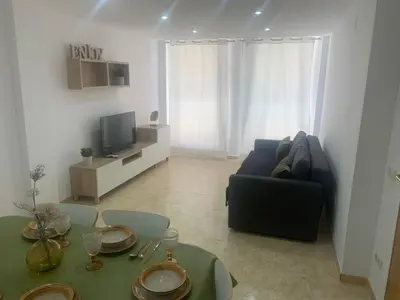 a living room with a couch and a table at UIM Mediterraneo Poeta 2 Wifi in Puerto de Sagunto