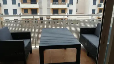 a black table and chairs on a balcony with a building at Nova Almenara. Ideal para familias in Barrio-Mar