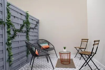 a patio with chairs and a wall with ivy at FLORIT FLATS - Valencia Port Rooms II in Valencia