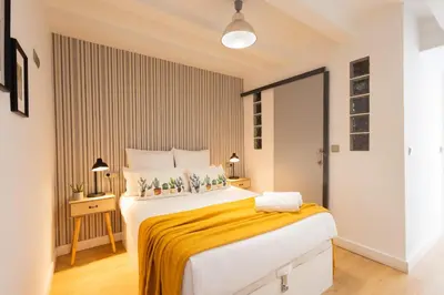 a bedroom with a large bed with a yellow blanket at FLORIT FLATS - The Soho in Ruzafa in Valencia