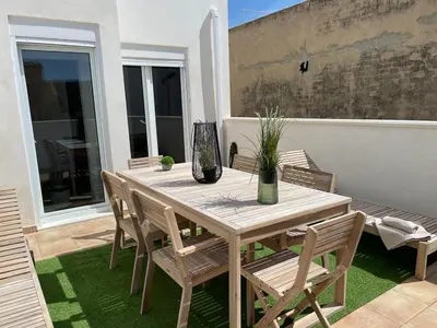 a wooden table and chairs on a patio at UIM Mediterraneo CASA Plomo Wifi in Puerto de Sagunto