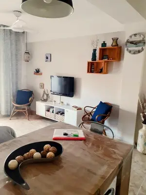 a living room with a table and a tv at APPARTEMENT VUE MER 40 METRES DE LA PLAGE in Cullera