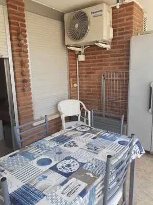 a table with a blue and white blanket on a patio at APPARTEMENT VUE MER 40 METRES DE LA PLAGE in Cullera