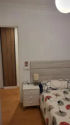 a bedroom with a bed and a table with a lamp at BioHomeValencia in Valencia